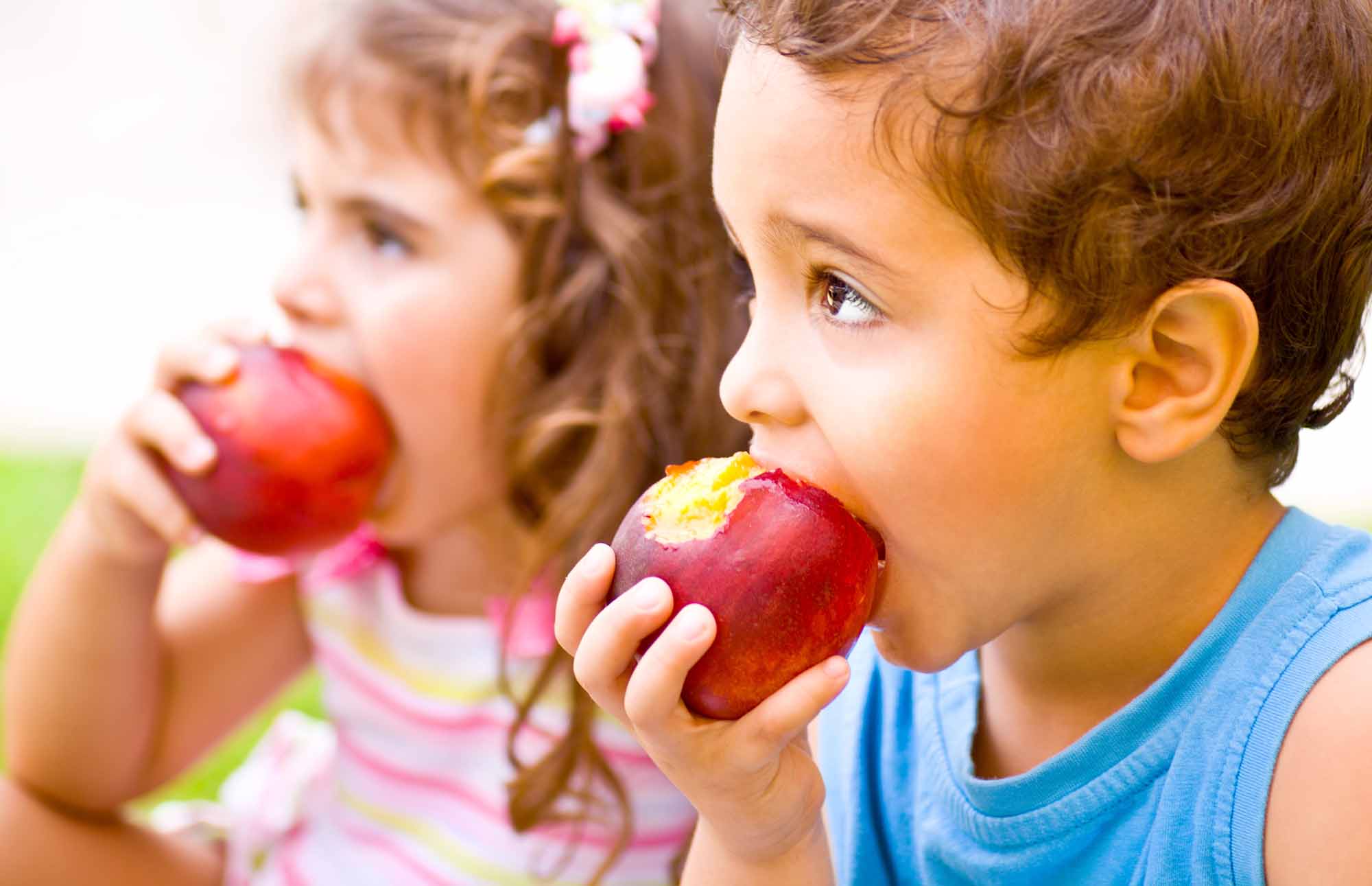 Happy children with healthy teeth eating apples - Smart Pediatric Dentistry, Utah