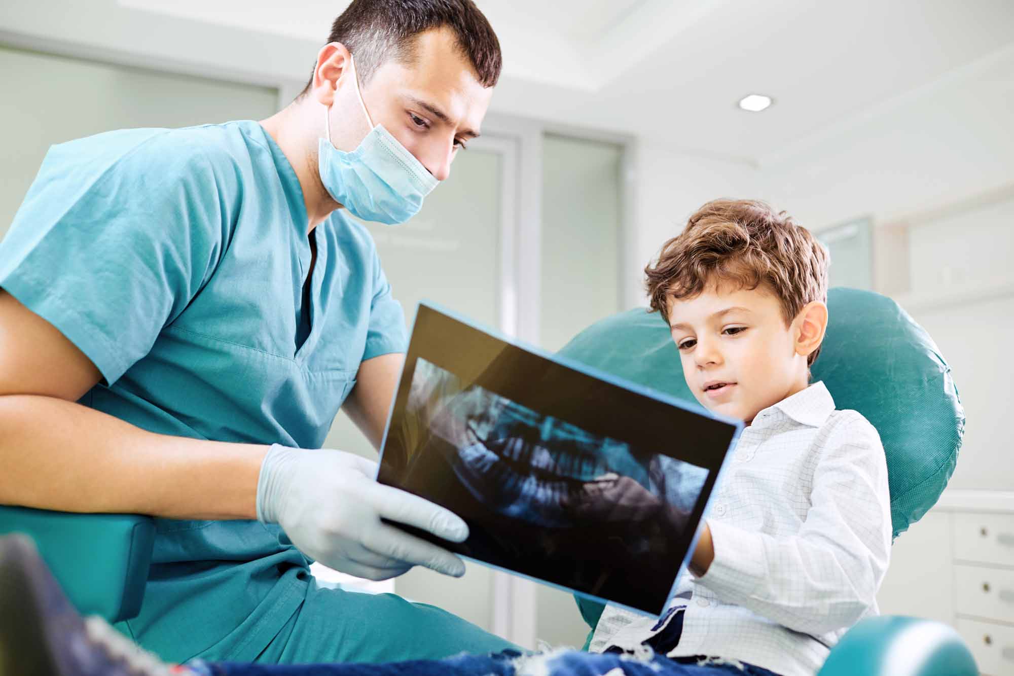 Dentist showing young boy an x-ray of his teeth - Smart Pediatric Dentistry, Utah