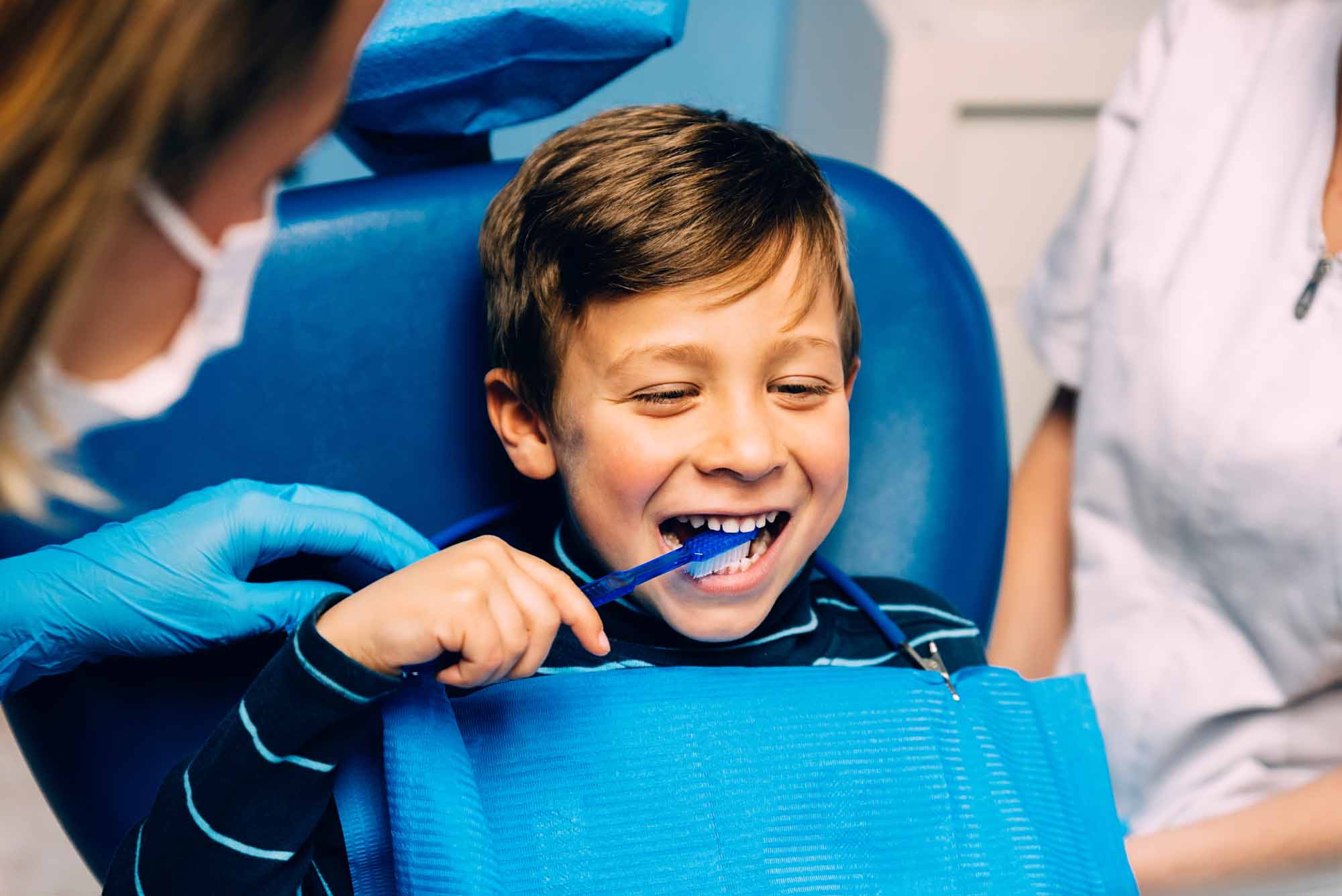 Pediatric dentist teaching child how to brush his teeth - Smart Pediatric Dentistry, Utah