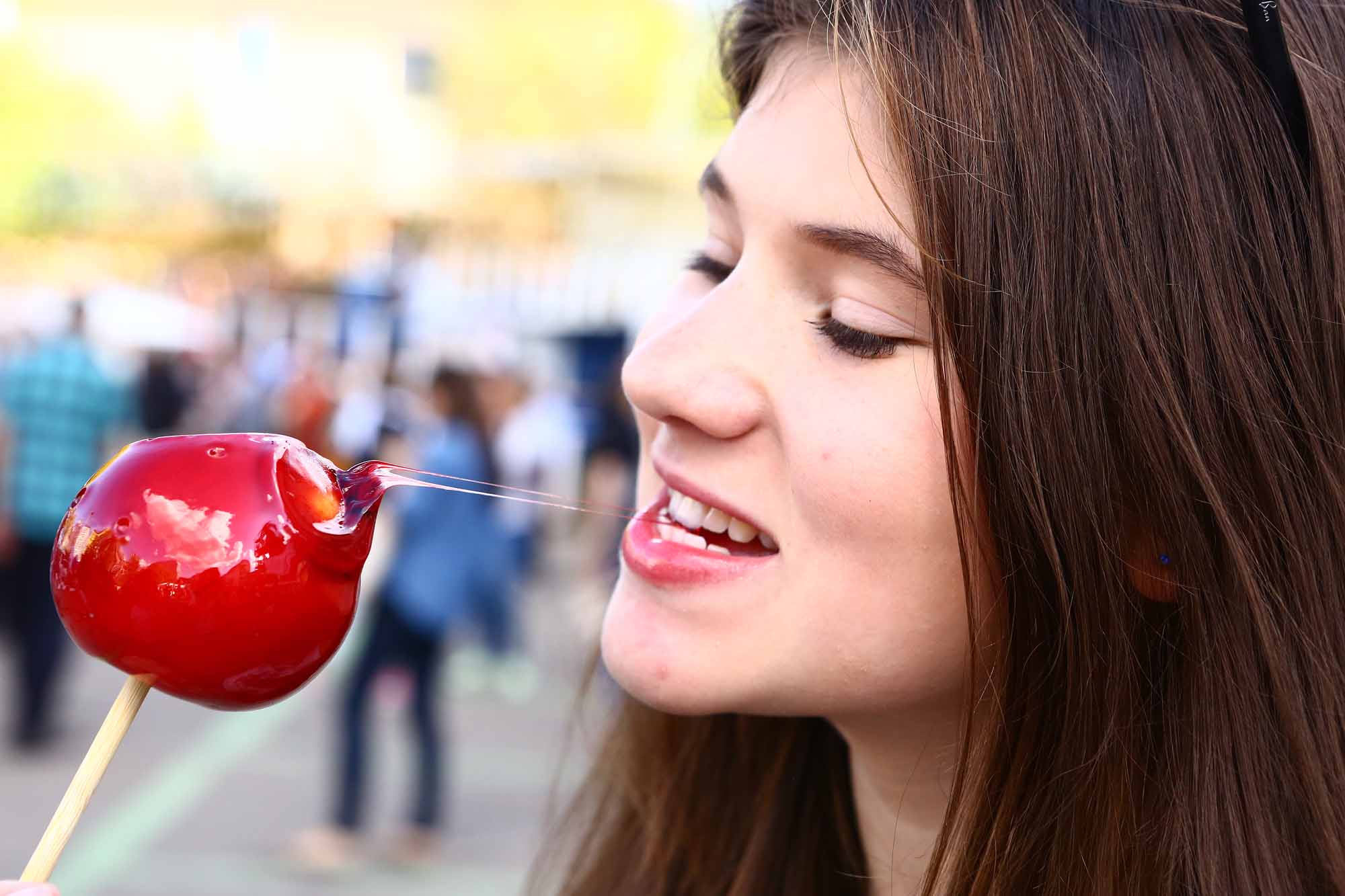 Teen girl biting into a caramel apple - Smart Pediatric Dentistry, Utah