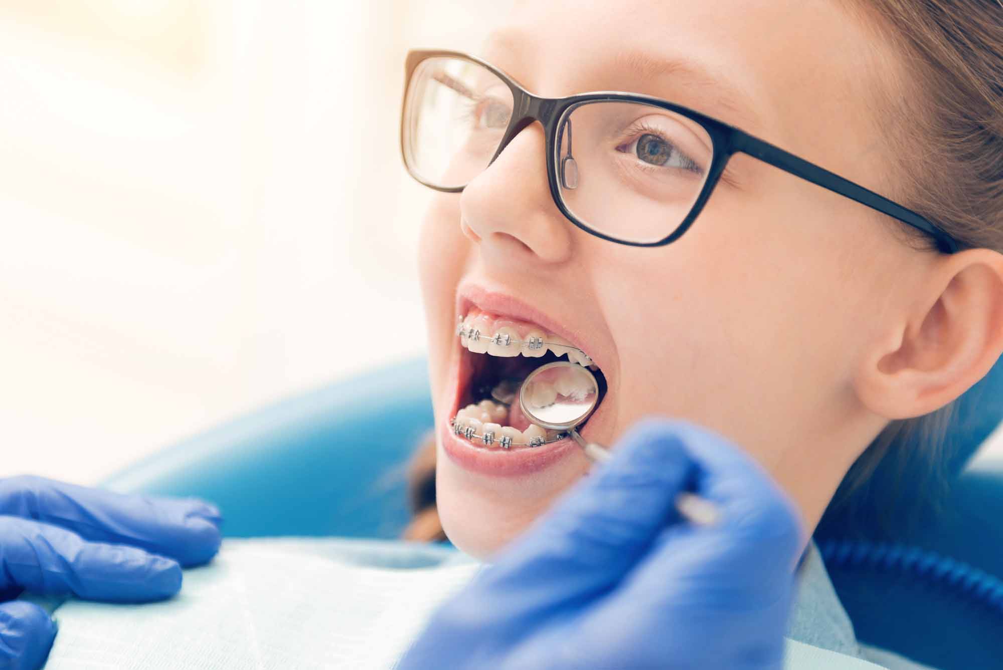 Young girl with braces getting treated by a dentist - Smart Pediatric Dentistry, Utah