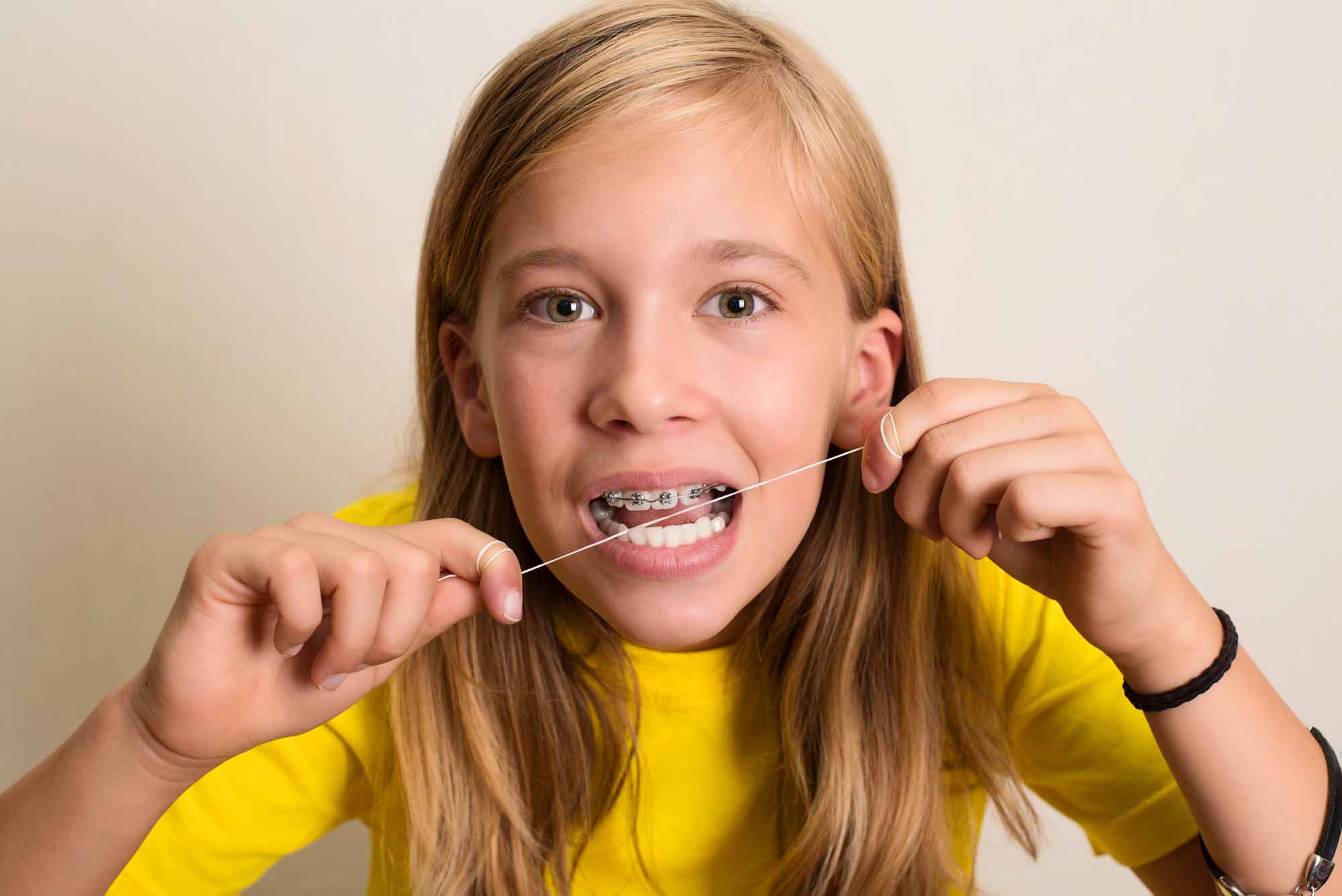 Young girl flossing her teeth - Smart Pediatric Dentistry, Utah
